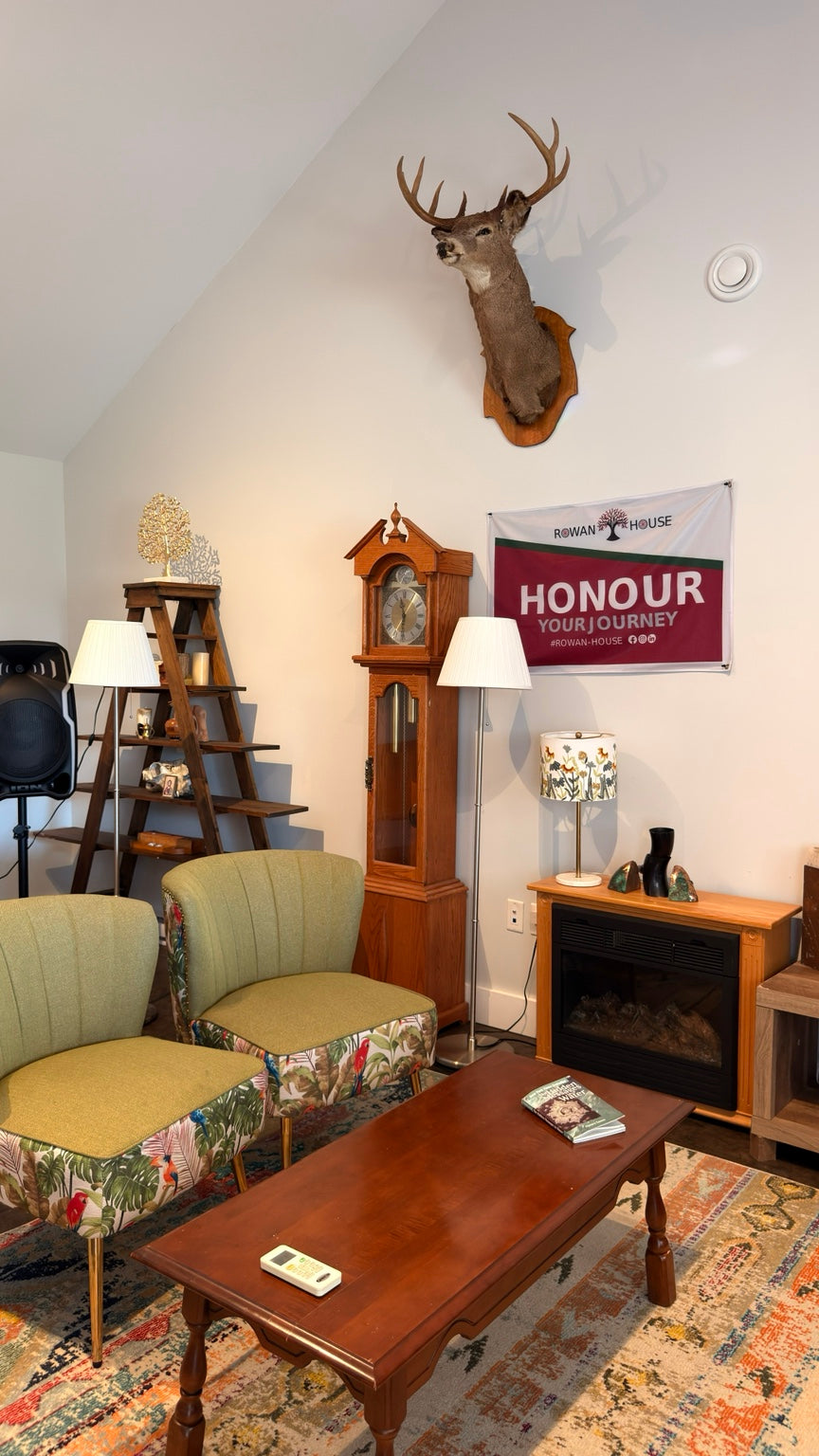 Rowan House interior — lounge with chairs, clock and fireplace